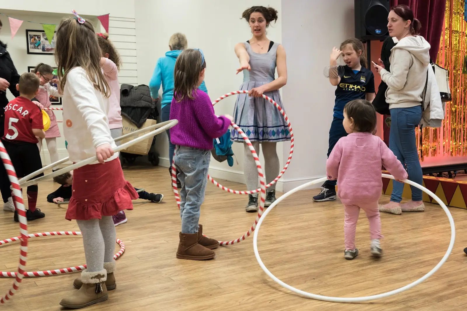 Children hula hooping with a Yorkshire Circus performer at a talent show